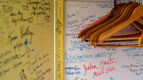 Closet wall at Mesa Refuge covered with handwritten names, dates, and notes.